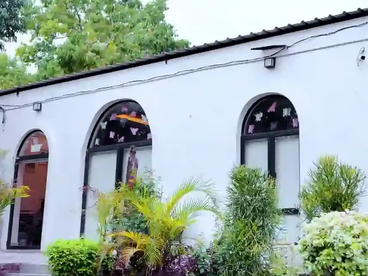 The Healing Room building in Bijwasan, New Delhi, with its arched windows and garden